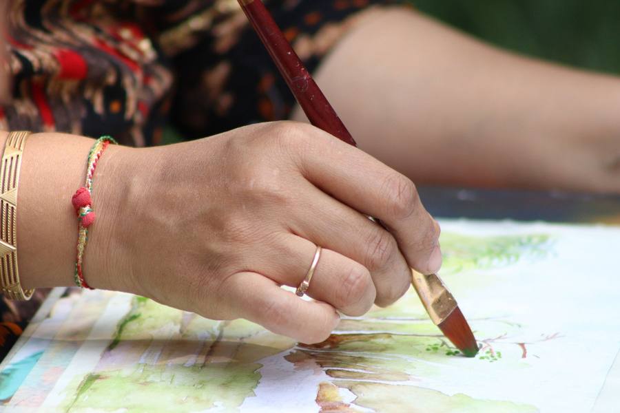 Hand painting a soft green watercolour landscape with a flat brush