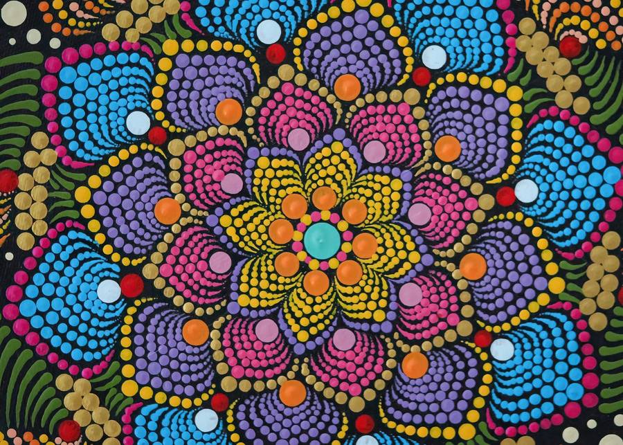 Close-up of a colourful dot mandala painted in blue, pink, purple and yellow dots